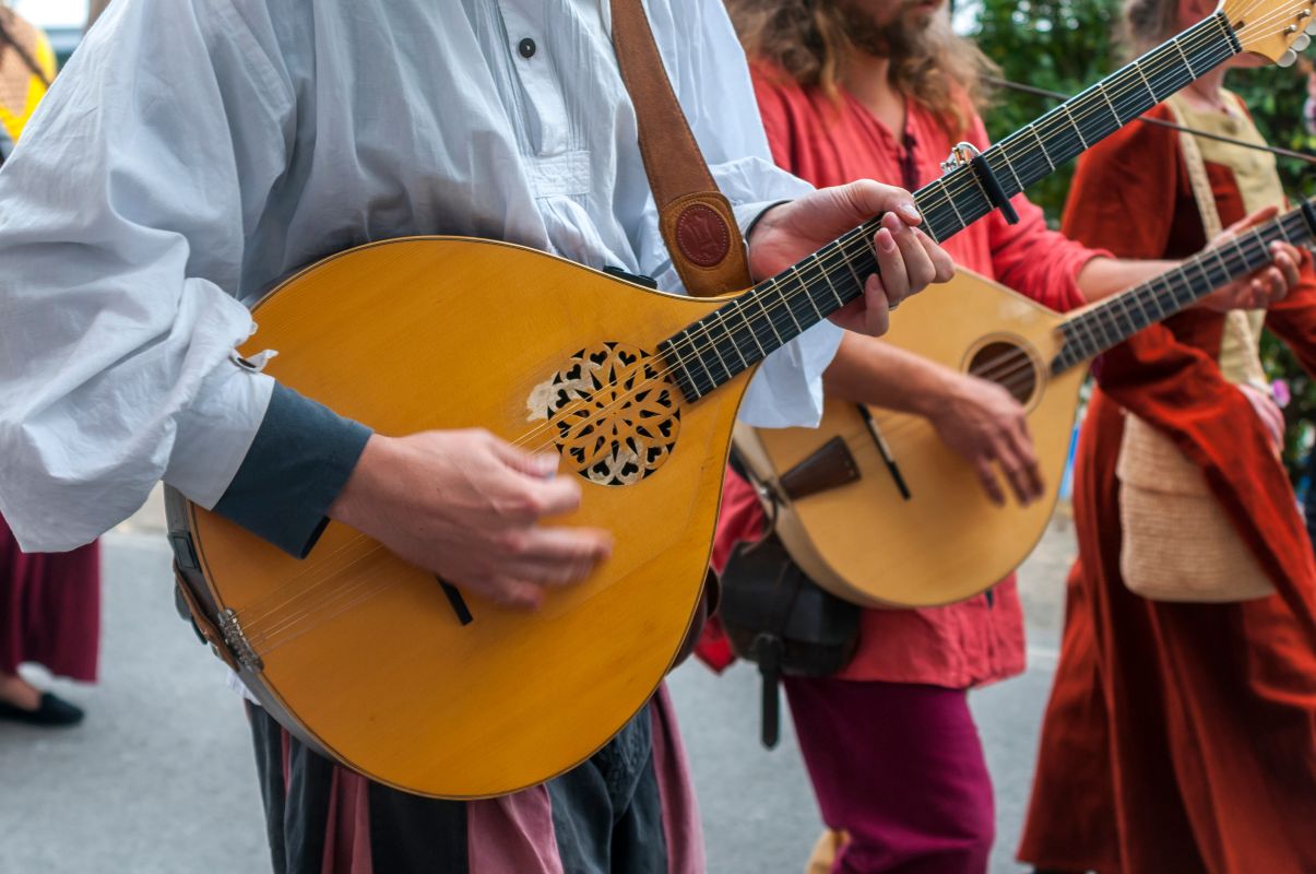 female child playing the Mandolin outside